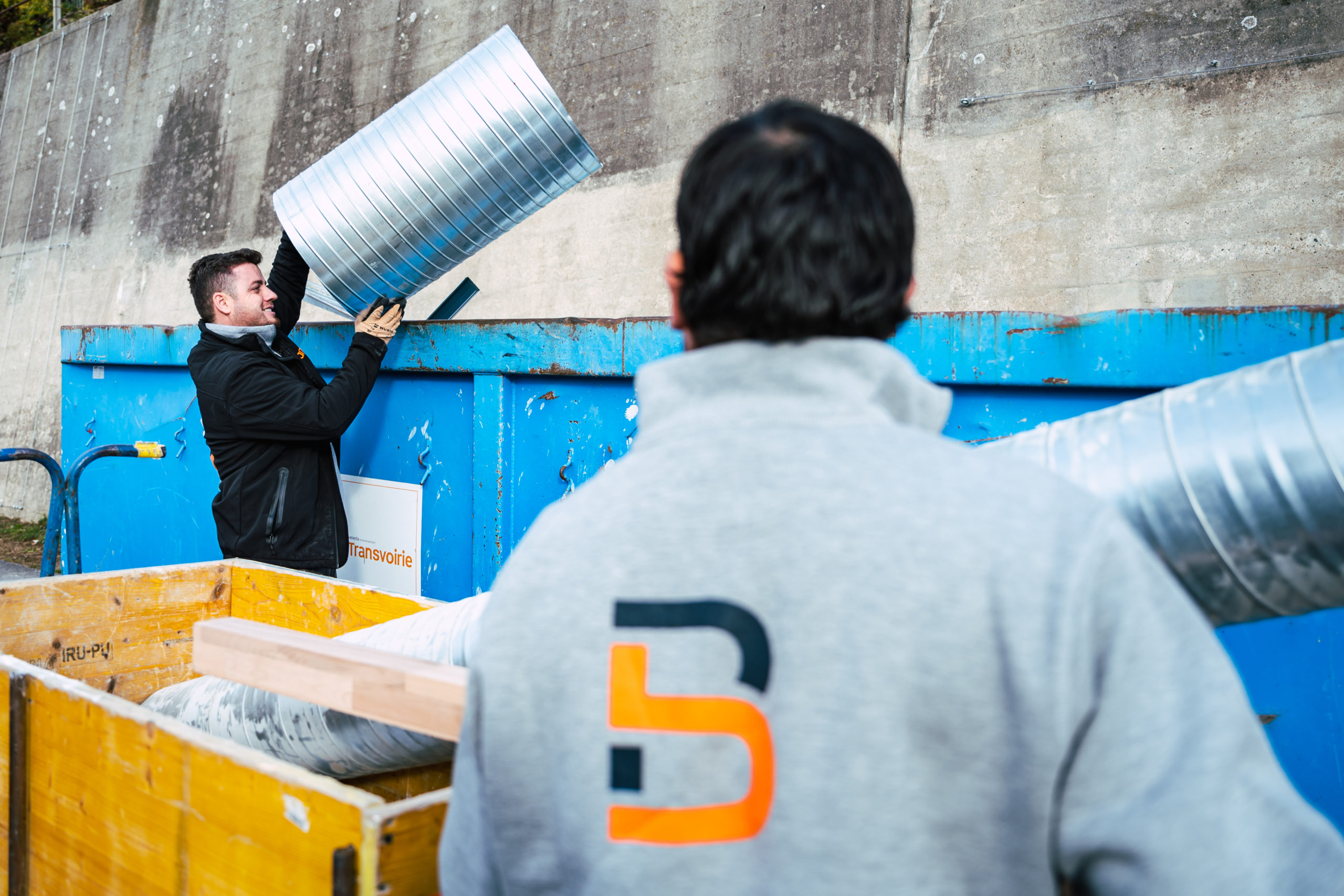 Agents Blanc SA manipulant des conduits de ventilation sur un chantier